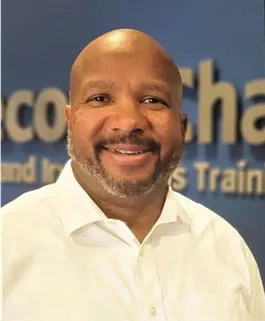 The CEO of Second Chance in yellow shirt smiling