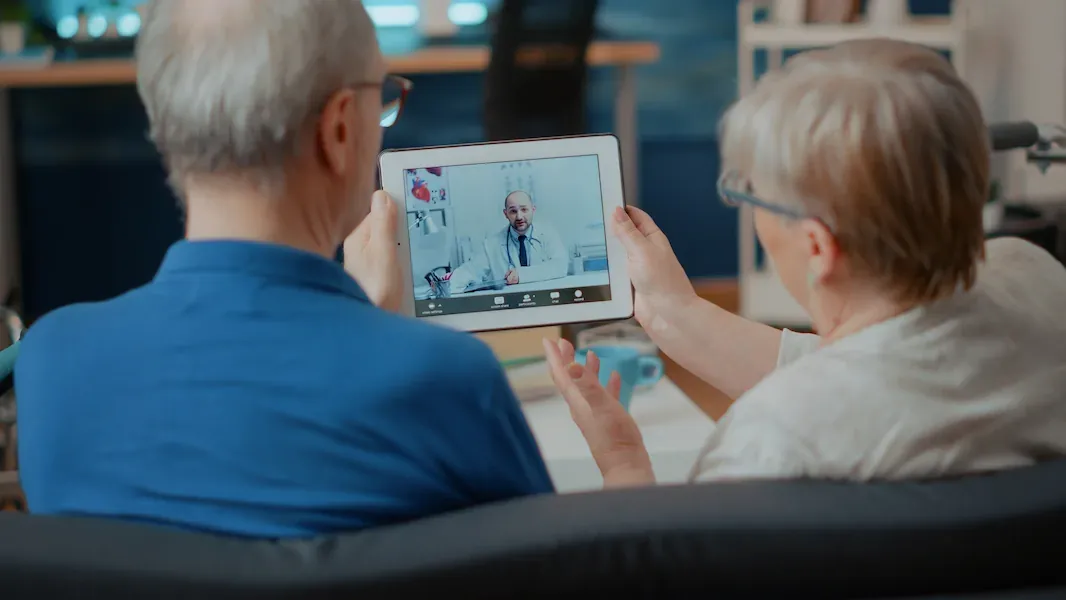 Senior couple sitting on a couch with tablet